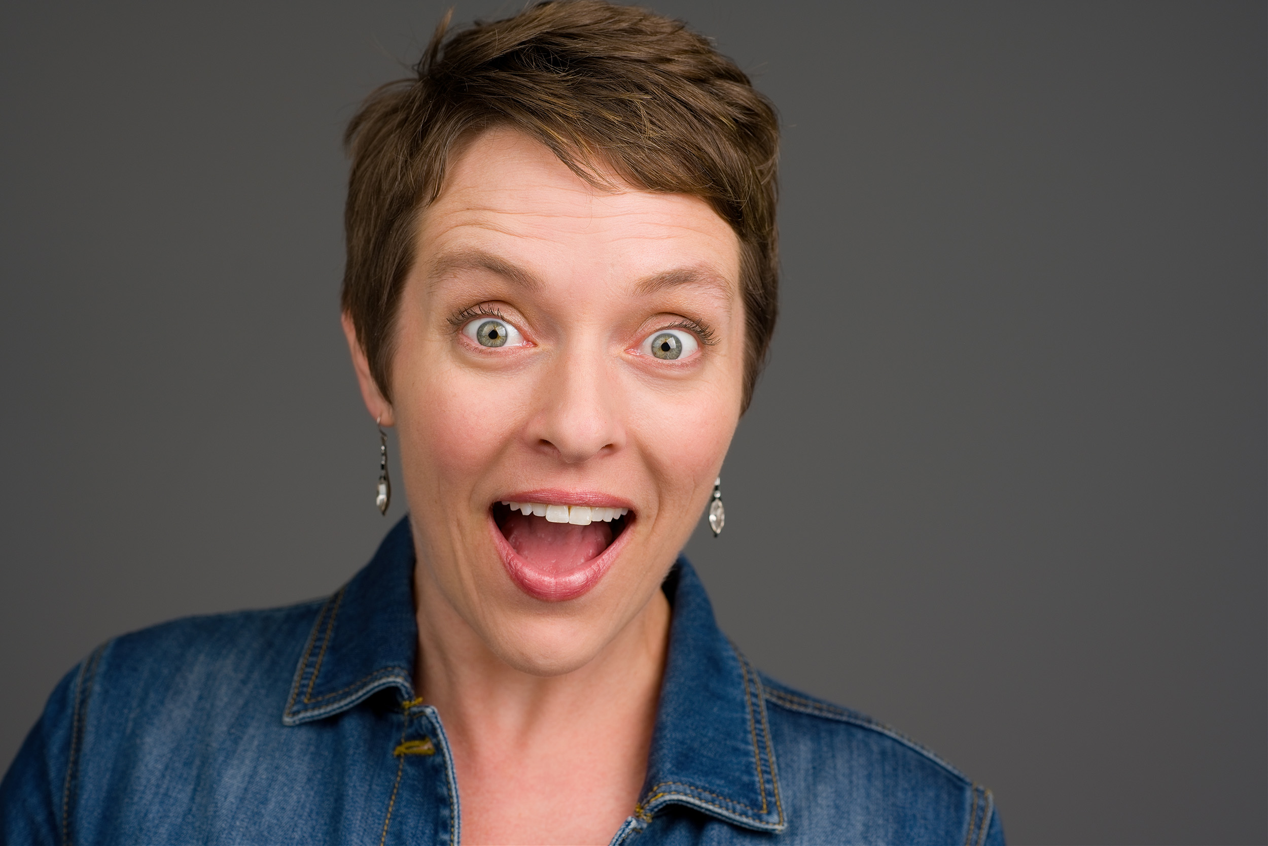 Woman expressing a happy surprise headshot.